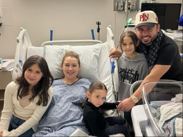 La familia completa de Larry Hernández y Kenia Ontiveros. El cuarto integrante duerme en su cuna, en la esquina inferior derecha, con su rostro cubierto para las redes sociales (Foto: Larry Hernández / Instagram)