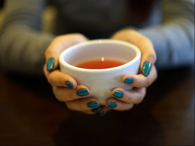 Esta imagen te muestra las manos de una mujer sosteniendo una taza donde hay una infusión. (Foto: Oleksandr Pyrohov / Pixabay)