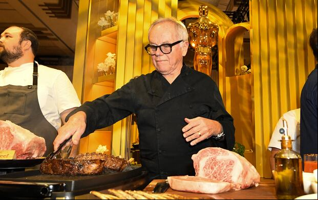El chef austriaco Wolfgang Puck cocinando carne en la previa de la 96° edición de los Premios de la Academia (Foto: AFP)